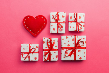 Fototapeta na wymiar Gift box with red hearts on coral background. top view with copy space