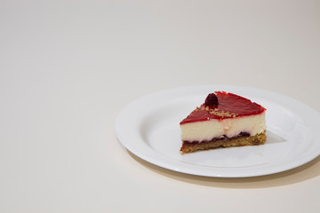 a slice of cheesecake on a white plate. Isolated on white background.