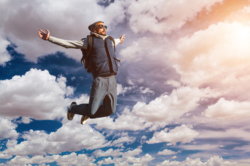 Young man jumping on top of a mountain against the sky