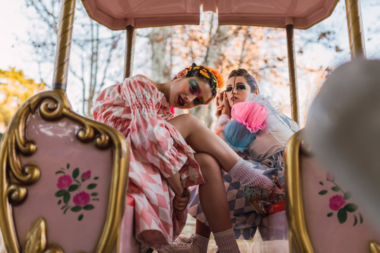 Street artists sitting on merry-go round on fairground