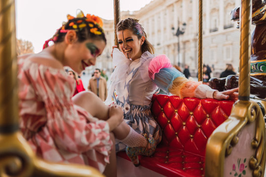 Street artists sitting on merry-go round on fairground