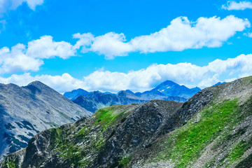 Beautiful alpine high mountains peaks, blue sky background. Amazing Mountain hiking paradise landscape, summertime.