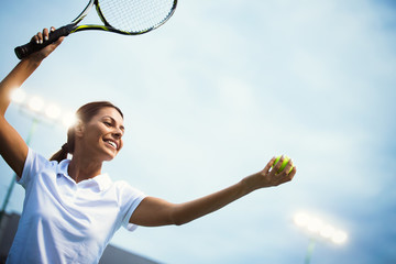 Woman tennis player smiling while holding the racket during tennis match