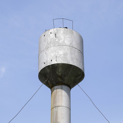 Silver Water Tower among green grass and trees