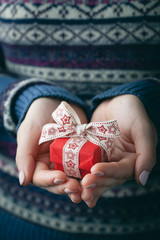 Close up shot of female hands holding a small gift