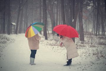 Two women walking in the winter forest