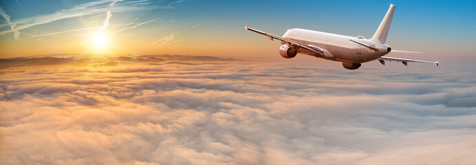 Naklejka premium Odrzutowiec samolotu komercyjnego latające nad chmurami dramatycznymi.