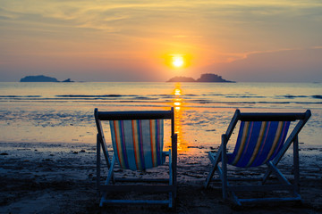 Fototapeta na wymiar Couple of sun loungers on the beach at sunset.