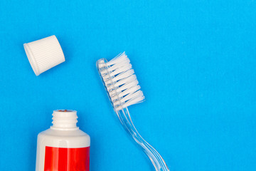 Toothpaste and brush on blue background