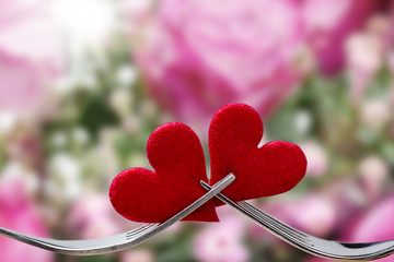 Valentine's Day, hearts and forks against background with Roses