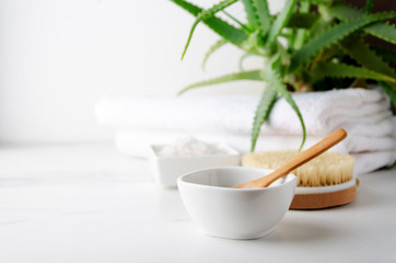 Closeup of container with white clay and spoon in it,body brush,bath salt