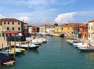 Fototapeta na wymiar Sunny summer day in Murano, Venice, Italy, boats and colorful houses around. Venice panorama view 