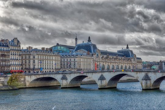Pont royal and Musee d'Orsay with Eiffel tower in backgroung in winter under a heavy sky - Paris, France.