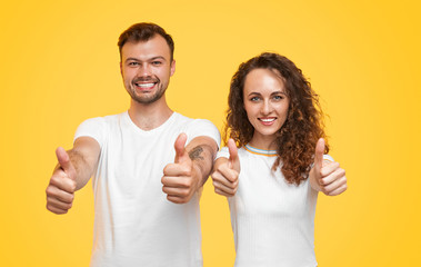 Cheerful couple gesturing thumb up