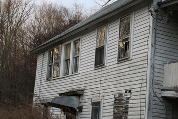 Old abandoned wooden weathered abandoned New England farmhouse 