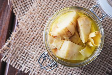 Pickled marinated artichokes in a glass jar on table