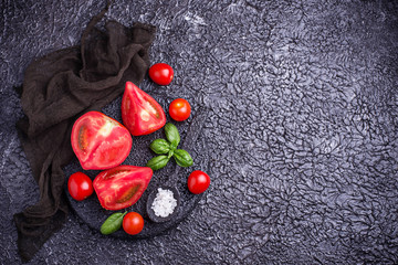 Sliced tomatoes on black background