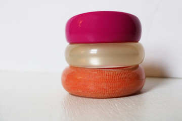 Brightly colored stack of bangle bracelets against white background