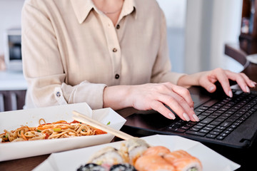 Woman tasting asian food at workplace, takeaway delivery service concept .