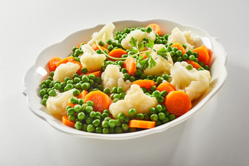Ceramic bowl of tender steamed mixed vegetables