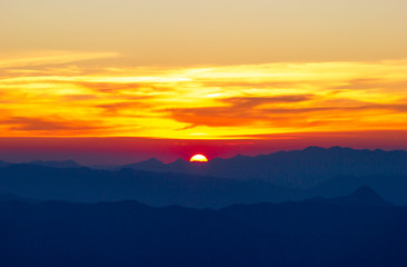 The sun is falling between mountains. Concept of entering the darkness at night or Loneliness and the end of the day.