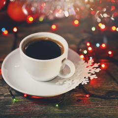 cup of coffee with cinnamon on a Christmas defocused background.