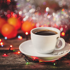 cup of coffee with cinnamon on a Christmas defocused background.