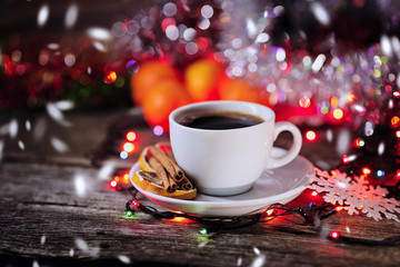cup of coffee with cinnamon on a Christmas defocused background.