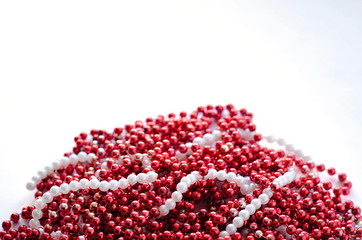 A lot of beads of white and red color on an isolated background.