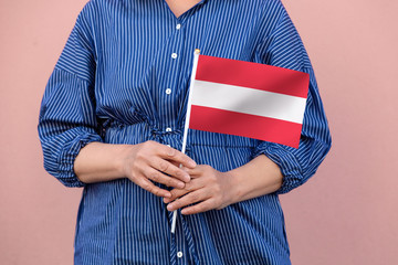Austria flag. Close up of a woman's hands holding Austrian flag.