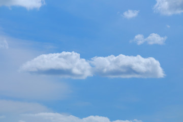 White fluffy clouds with blue sky and sun light for background texture 