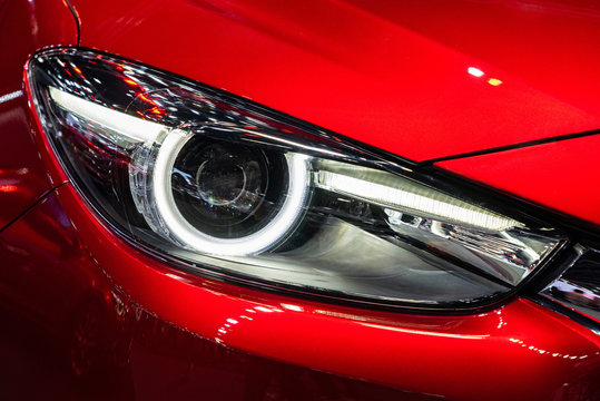 White Headlight Of Red Car With Front Hood And Bumper