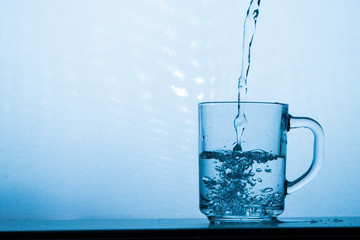 Naklejka na ściany i meble Water splashing from a glass