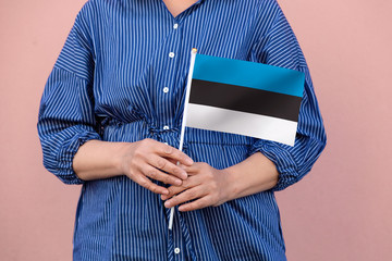 Estonia flag. Close up of a woman's hands holding Estonian flag.