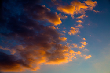 Colors of Afterglow Illuminating the Blue Sky. Gray and Golden Clouds Forming an Abstract Cloudscape Artwork. Colourful and Dramatic Thick Fog Scattering