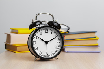 Back to school background with books and alarm clock