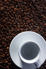 Empty cup on the background of coffee beans