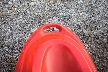 Stern the Rear End of Kayak on Mixed Stones Surface.Back Part of Orange Water Boat. Extreme Watersport Outdoor Adventure. Wear and Tear of Used on the Edge