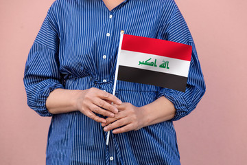Iraq flag. Close up of woman's hands holding Iraqi flag.