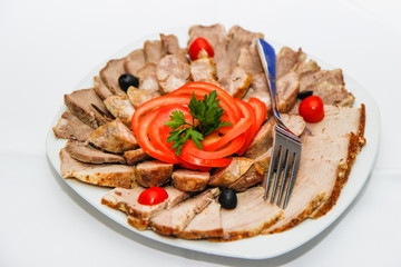 baked meat in the oven sliced in portions and beautifully served on a plate in a restaurant