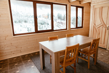 dining room of wooden house with table and chairs and large window with beautiful view