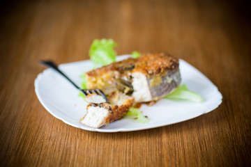 piece of fried pike fish in a plate on a wooden