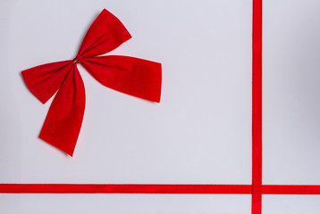 small red bow on a white background with red ribbons