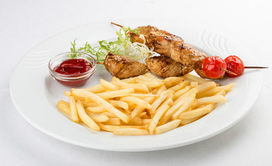 French fries with chicken skewer with red sauce. On white background