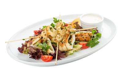 Squid grilled on skewers, with salad and sauce. On white background