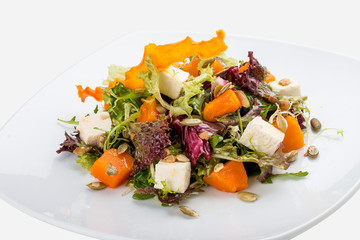 Salad with pumpkin and feta on a white background. Vegetarian