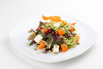 Salad with pumpkin and feta on a white background. Vegetarian