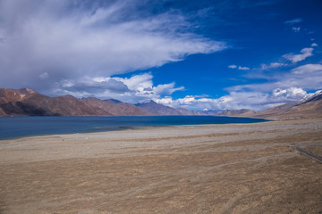 Fototapeta na wymiar View of Lake Pangong with beautiful mountains in blue sky and reflection. Leh Ladakh, India