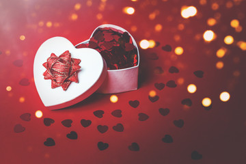 Heart shaped gift box with heart confetti. Passion, love and feelings St Valentine's celebration concept with copy space