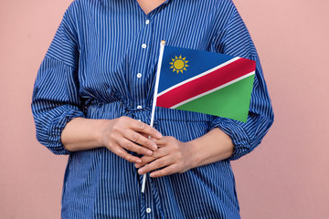 Namibia flag. Close up of woman's hands holding Namibian flag.